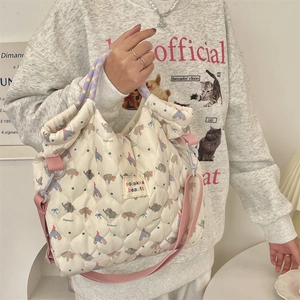 Detail showing quilted texture of cream handbag with cute cartoon elephant prints