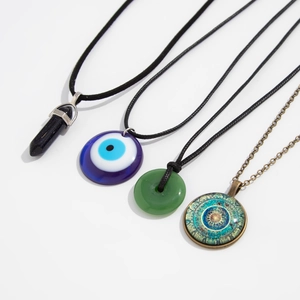 Detail of four vintage ethnic necklaces with evil eye and mandala pendants
