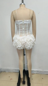 Detail of the white mesh tube dress featuring 3D floral petals and a gold back zipper