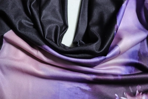 Close-up of soft purple digital print fabric with smooth texture and silky drapes