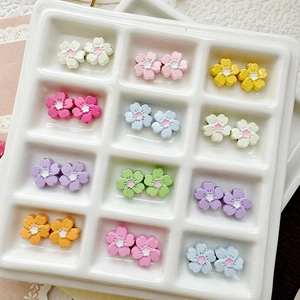Close-up of colorful flower-shaped DIY beads neatly arranged in a white grid tray