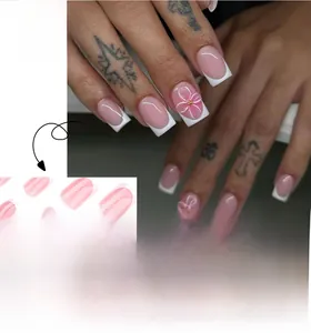 Detail of French pink press-on nails with 3D white flowers and gold bead accents