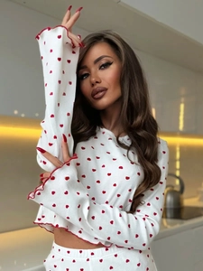 Close-up of wavy bell sleeves and red heart print on white knit lounge set