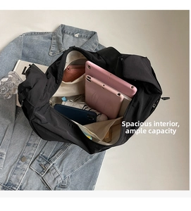 Internal view of a black nylon crossbody bag showing spacious main compartment and pockets