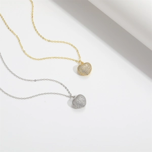 Detail view of heart-shaped pendant necklaces in gold and silver finish with crystal pavé