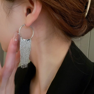 Silver circle earrings with long chain tassels worn on model with black suit blazer