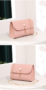 Detail of pink quilted PU leather handbag with gold tassel and pearl cat clasp