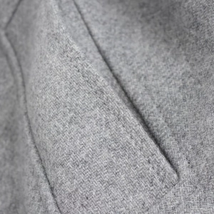 Macro detail of side pocket stitching and high-quality grey wool fabric texture