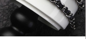 Macro detail of the black metal chain interwoven with premium black leather strips