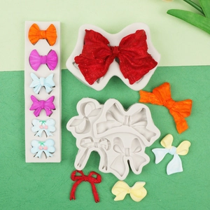 Detailed view of silicone bow molds with colorful resin bow models on a green background