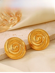Vue détaillée de boucles d'oreilles spirales dorées à texture sur soie beige