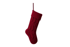 Detail of red cable-knit Christmas stocking showing intricate textured patterns and fold over cuff