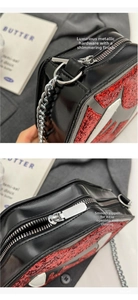 Close-up of premium silver chain hardware and smooth zipper on a red glitter lip bag