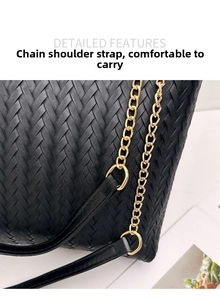 Detail of black woven leather tote featuring elegant gold chain strap and texture