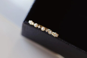 Macro detail of gold ring with inlaid freshwater pearls and sparkling small crystals