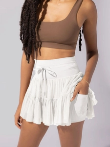 Detailed view of white pleated sports skirt showing mesh fabric texture and side pocket