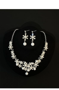 Detail of silver floral jewelry set with white faux pearls and clear rhinestones