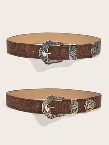 Close-up of brown textured belts with floral embossing and vintage pin buckle hardware