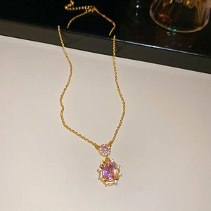 Macro shot of gold necklace with pink oval gemstones and sparkling cubic zirconia details