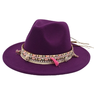 Detail of bohemian fedora hat with ethnic woven band, tassels and shell charms