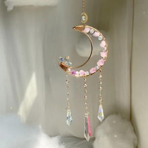 Macro detail of crescent moon suncatcher with purple stones and crystal prisms
