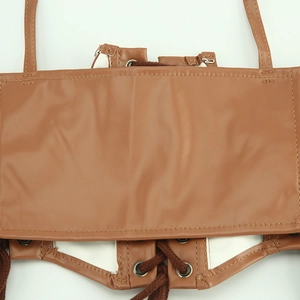Detail of light brown faux leather vest featuring back lace-up straps and metal eyelets