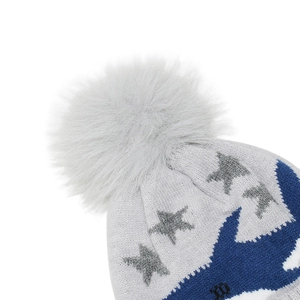 Detailed close-up of a blue shark jacquard knit pattern and a grey faux fur pompom ball