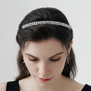 Close-up of elegant silver floral headband and matching leaf earrings with clear crystals