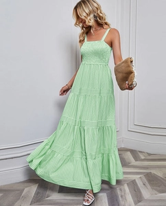 Detailed close-up of smocking texture and light green striped tiered maxi dress