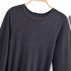 Dark grey knitted long sleeve top with a round neck displayed on a wooden hanger