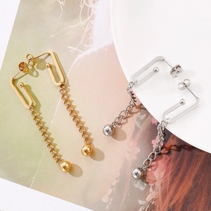 Detail view of geometric chain earrings in gold and silver finish with ball drops