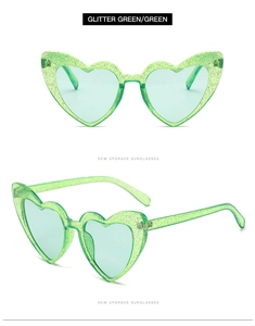 Close-up of glitter green heart sunglasses with sparkling frames and transparent lenses