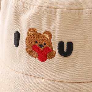 Detail of bear embroidery and 'I love U' lettering on beige canvas bucket hat