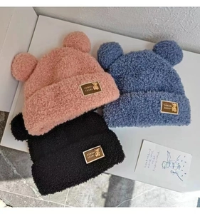Detailed flat lay of lamb velvet beanies with bear ears in pink, blue and black colors
