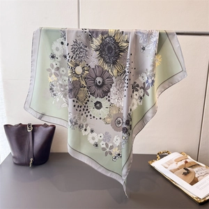 Detailed shot of large square daisy silk scarf with sunflower print and rolled edges