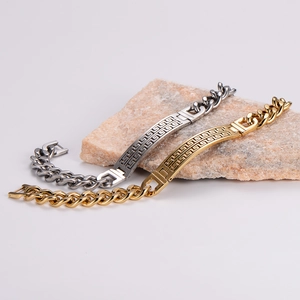 Detailed shot of gold and silver cuban chain bracelets with Greek fret pattern engraving