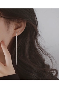 Close-up of elegant long silver tassel drop earrings on a model with minimalist design