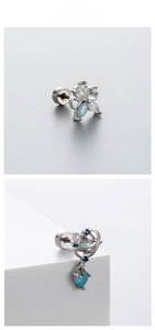 Detailed macro of flower and planet design surgical steel cartilage studs with blue zircon
