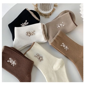 Detailed knit texture of cotton crew socks with cute rabbit embroidery in earthy tones