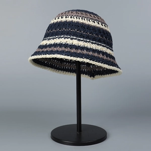 Detail view of the breathable knit hollow texture and striped pattern on the sun hat