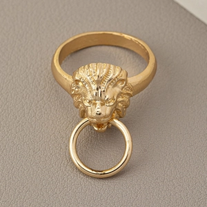Macro shot of a vintage gold-toned lion head ring with a punk style door knocker design