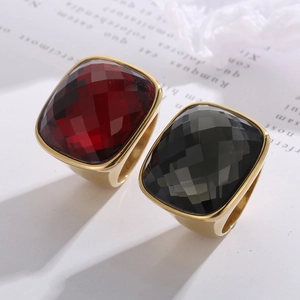 Close-up of vintage wide gold rings with square-cut wine red and black crystal stones