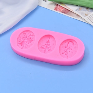 Pink silicone baking mold featuring Christmas tree, bells, and bow patterns on blue background