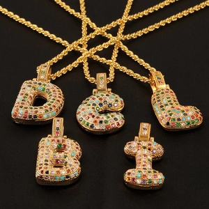 Macro shot of colorful cubic zirconia alphabet pendants on gold-plated rope chains