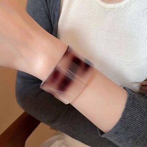 Detailed view of wide tortoiseshell acetate cuff bracelet on a model wrist
