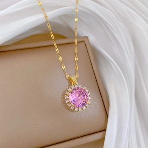 Macro shot of a pink circular zircon pendant with micro-pave diamonds on a gold chain