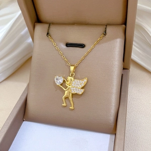 Detailed macro view of gold plated Cupid angel pendant with heart cubic zirconia and stones
