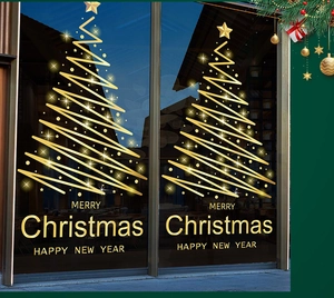 Close-up of golden Christmas tree stickers and festive greetings on a glass door