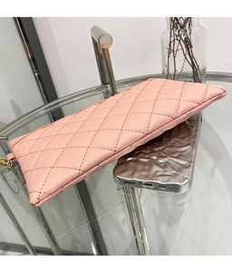 Dettaglio della pochette rosa in pelle sintetica trapuntata con zip e gancio in metallo