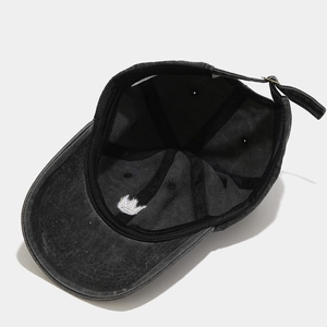 Detail view of cotton baseball cap interior with crown embroidery and metal buckle strap